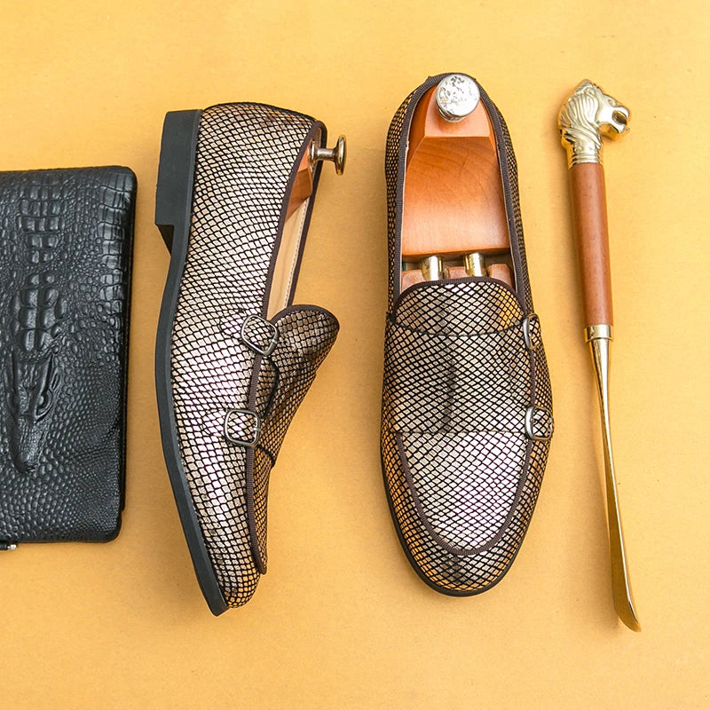 gold mesh loafers with a gold shoe horn on a yellow background